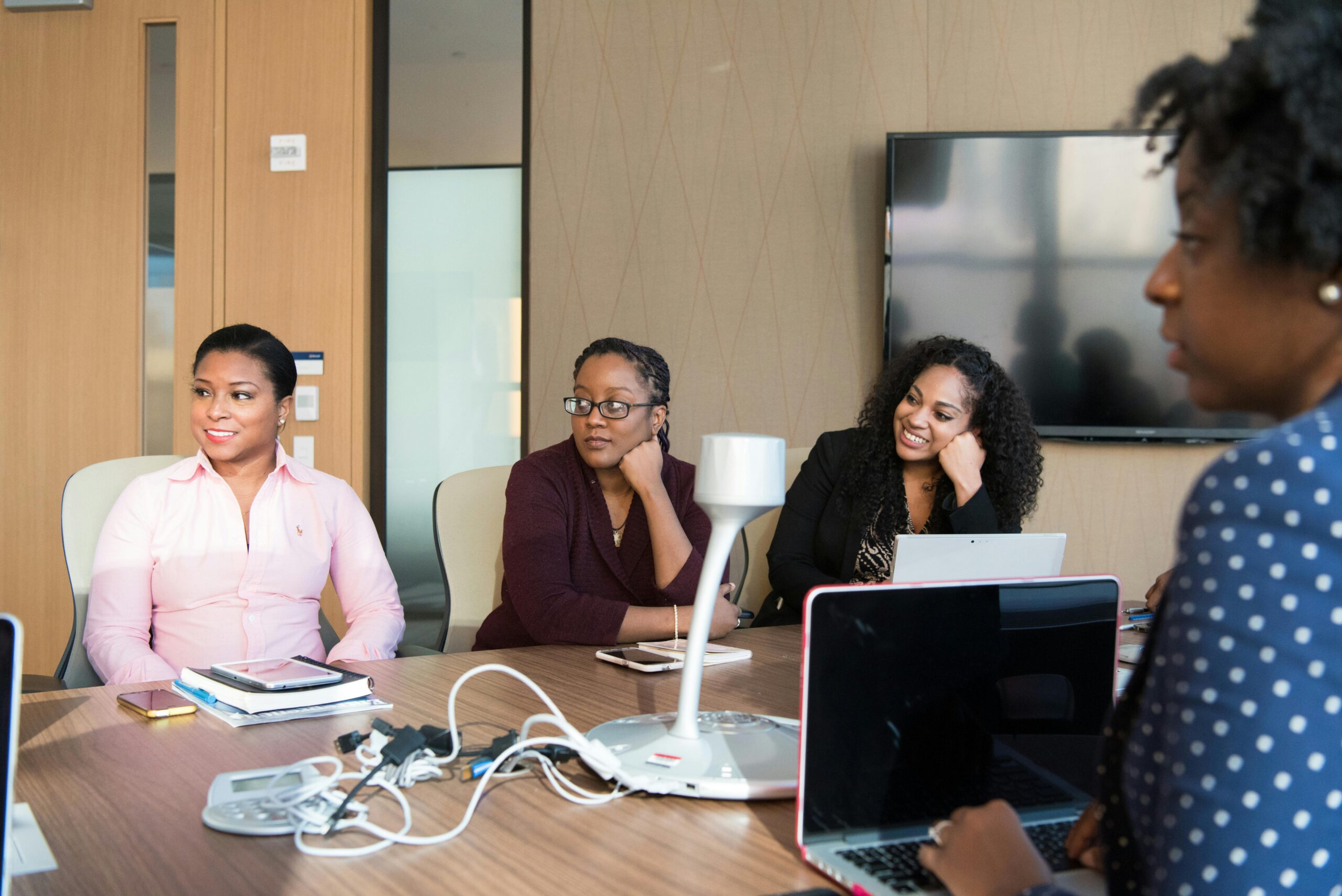 Group of women engaging in a collaborative meeting in a modern office setting.